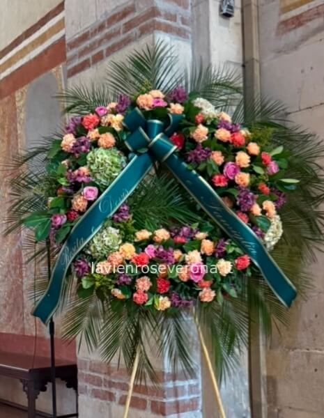 Corona funebre con fiori freschi assortiti, colorata.