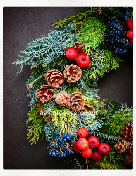 Coroncina natalizia con abete, bacche e decori.